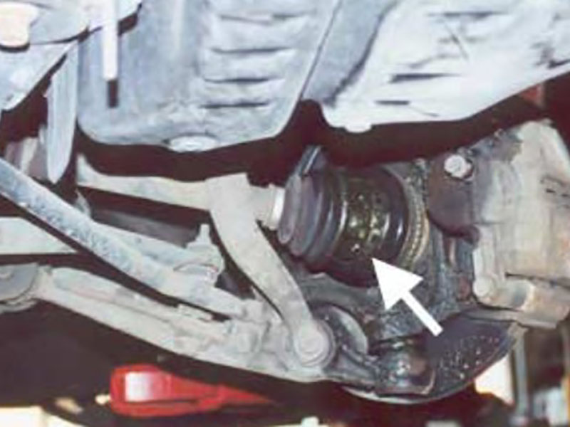 Torn CV boot with grease splatter and worn Rzeppa joint race grooves showing bearing scoring and cage damage, common failure symptoms including clicking on turns and vibration under acceleration