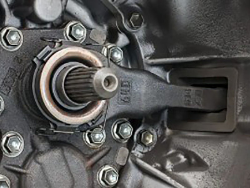 Cutaway view of manual transmission bell housing showing clutch release bearing (throw-out bearing) positioned between clutch fork and pressure plate diaphragm spring