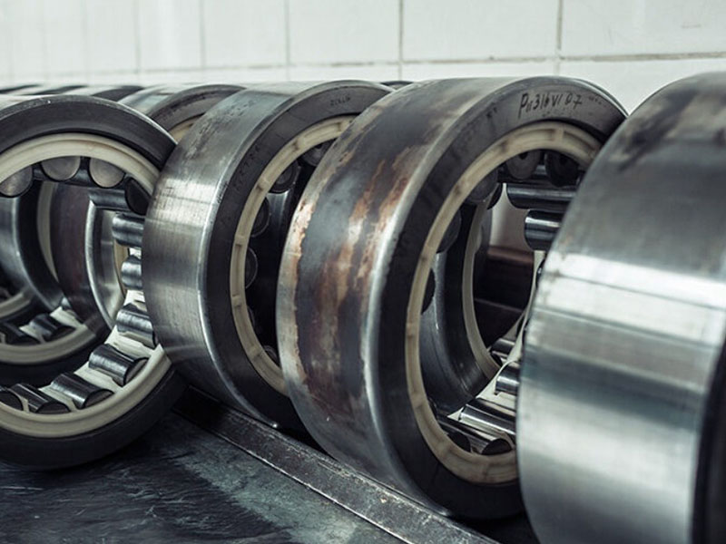 Worn needle roller bearing raceway with scuffing marks and false brinelling indentations showing common failure modes like wear and overheating